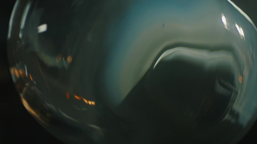A transparent glasstextured object with some lights reflecting on its surface