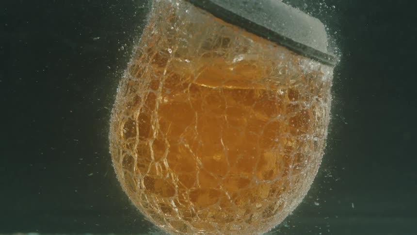 Close up of a hot glass cooling in water