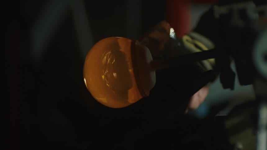 Hand reaching towards a forged glass globe