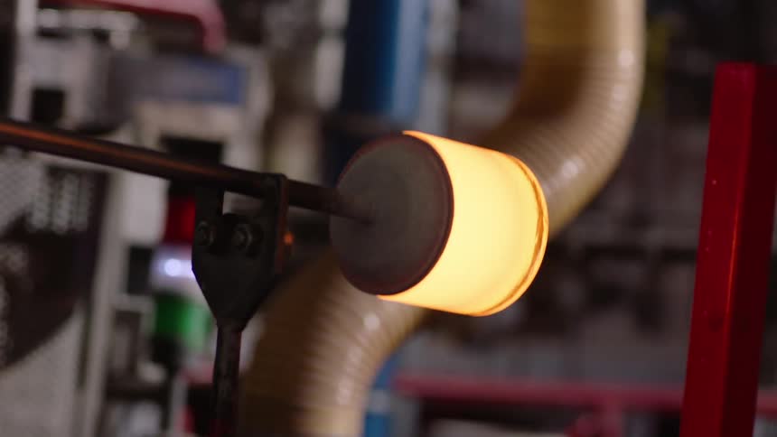 Gloved hand picking up an object with heated glass
