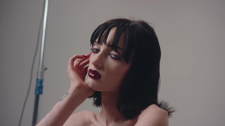 Portrait of a young woman with red lipstick and black hair in an indoor space