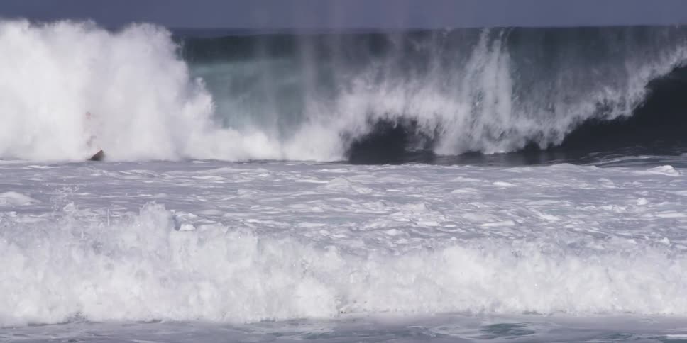 Two people are riding a wave