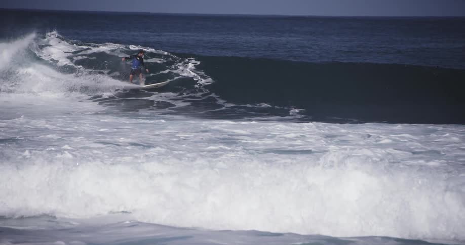 A man surfs on a clear day