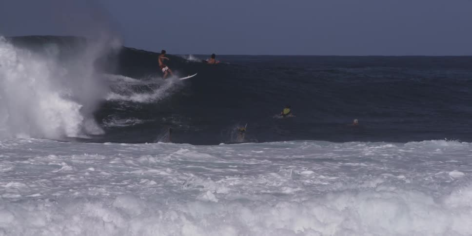 A surfer rides a large ocean wave