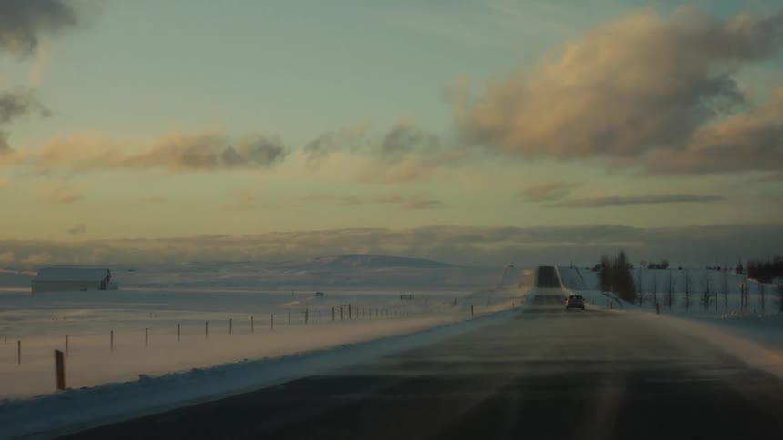 A mist is coming off the snow as cars drive by