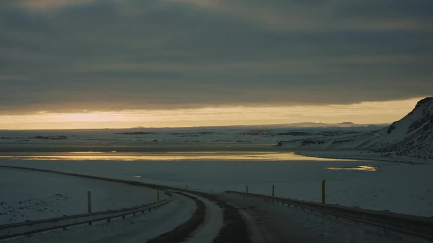 A road runs through a snow filled landscape
