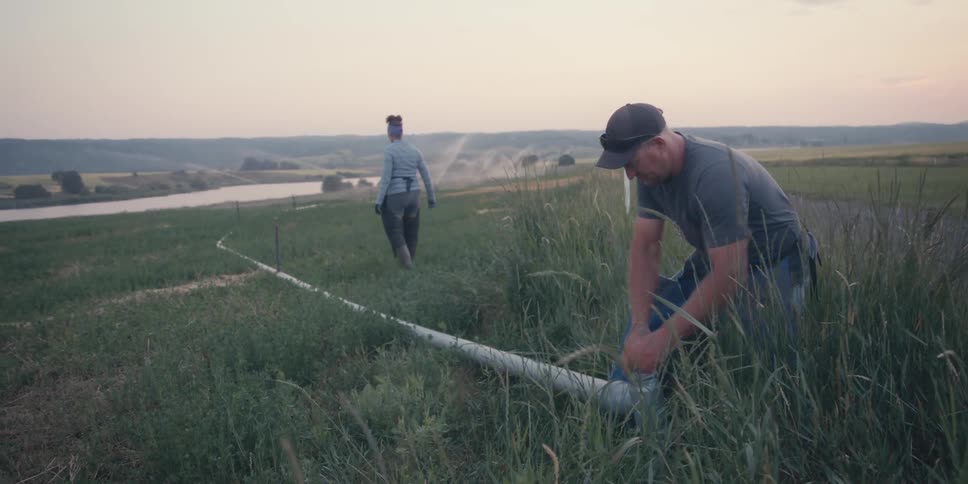 Man setting up an irrigation system in a rural area