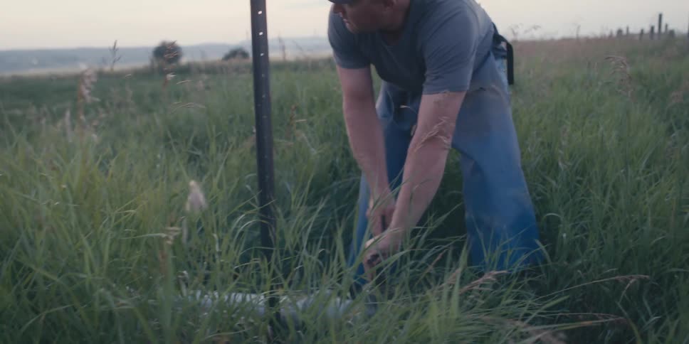 A man turns the spigot on an irrigation system