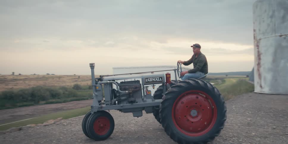Man driving a gray tractor