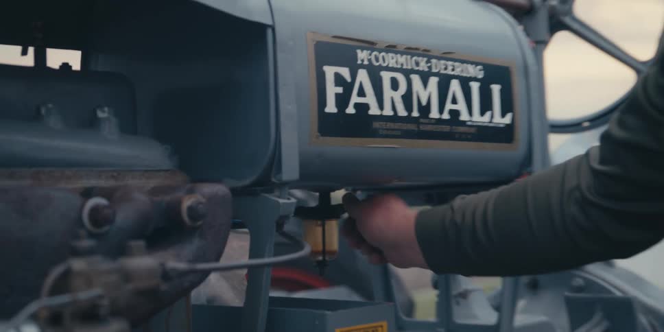 Man adjusting the engine of a farm tractor