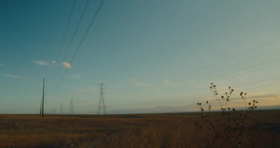 Large power lines cross the flat field