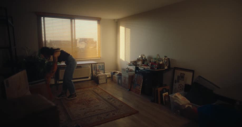 Woman in living room pulling a box into the center of a rug