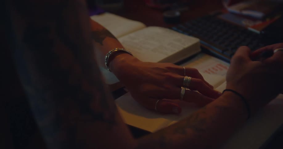 Pair of hands of a person on the table with books