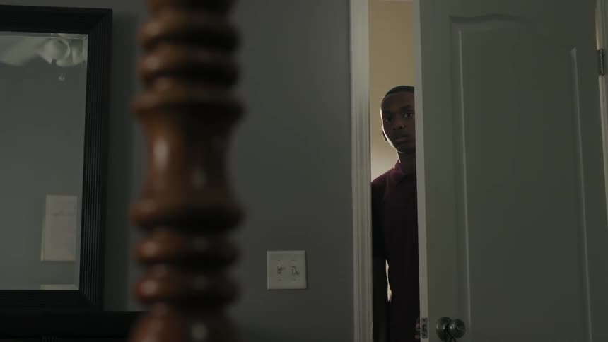 A boy opens a bedroom door and peaks inside