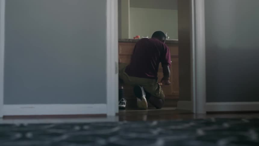 A boy looks through bathroom cupboards