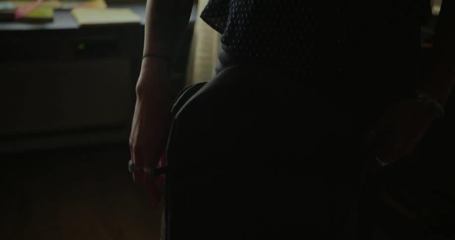 Womans hand putting objects inside a backpack
