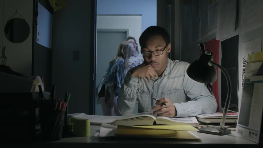 A man sits working at a desk and shuts the door after two teen girls walk by