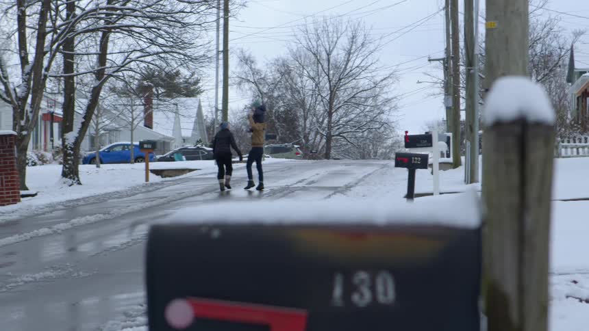A clip of a family walking in the street covered with snow