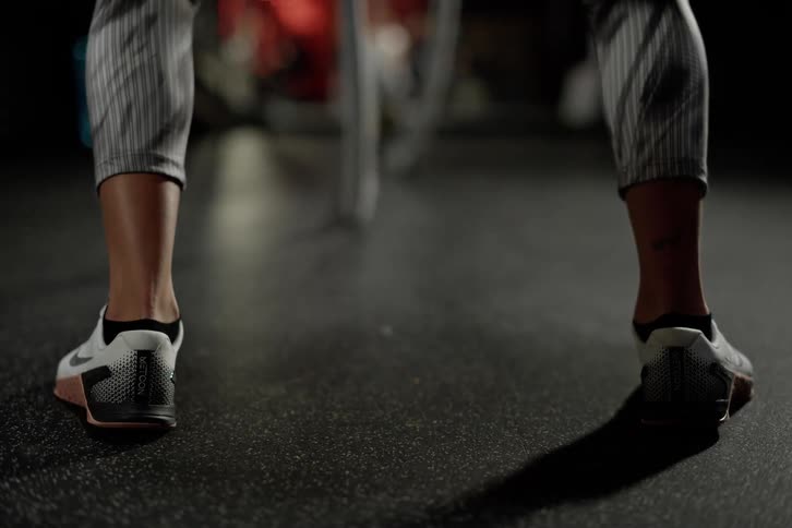 Feet of a woman exercising with battle ropes in a gym