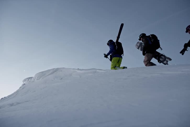 Group of four people climbing a mountain with ski equipment
