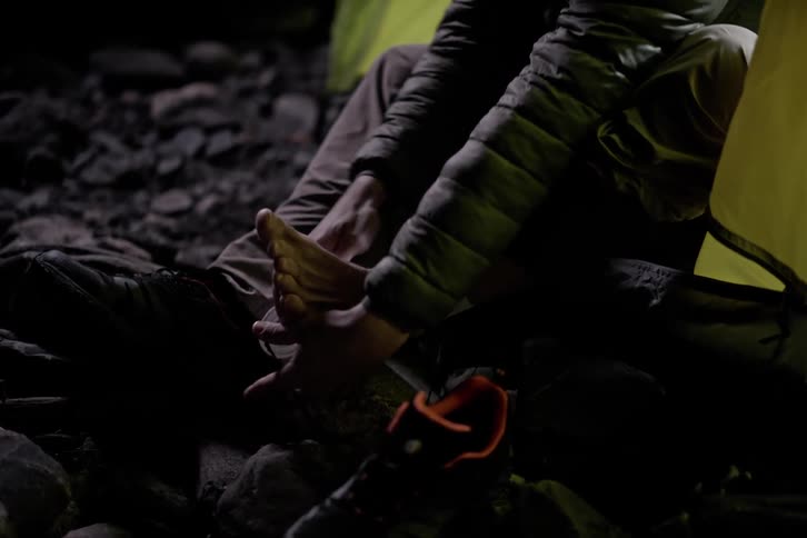 A man is sitting in his tent at night