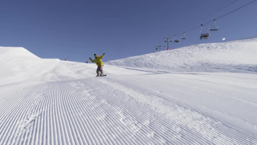 A snowboarder rides down a mountain