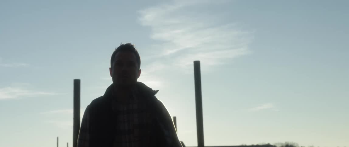 Man walking down a dock on a sunny day
