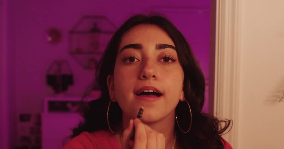 Woman putting on makeup in a room