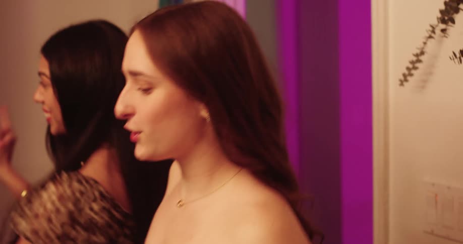 Teenage girls having fun dancing while putting on makeup in the bathroom at home