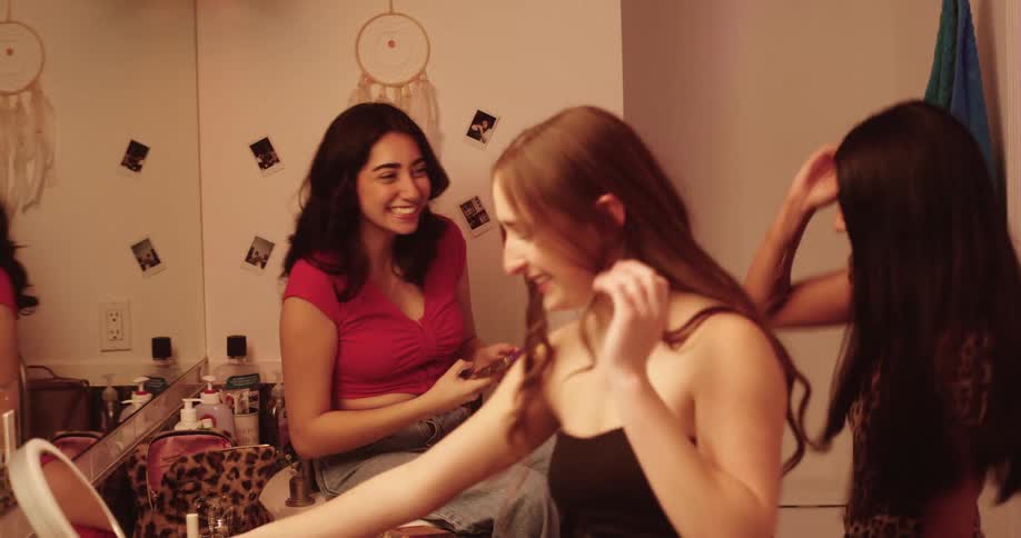 Three friends dancing together in the bathroom while getting ready