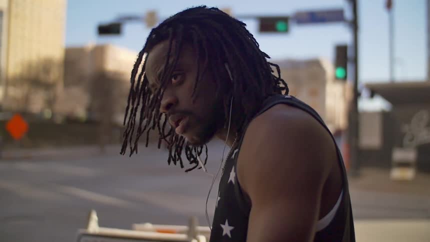 A man standing at a city intersection looks up