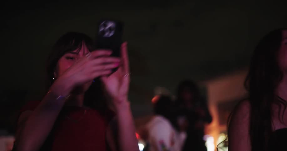 Four friends in an outdoor setting at night dancing