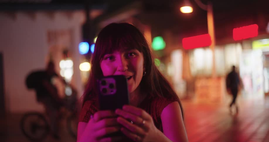 A teenage girl is counting down before taking a picture with her phone at night