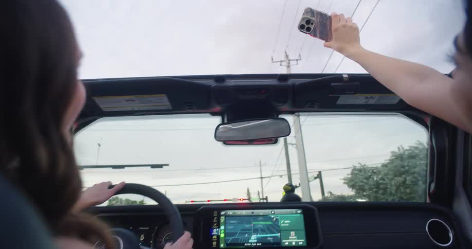 Three happy friends taking a selfie inside a convertible car