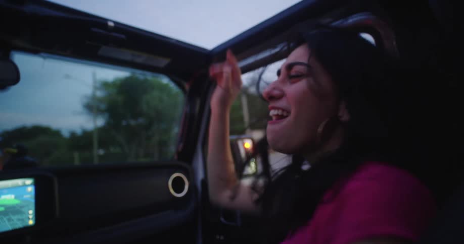 Two friends having fun inside a convertible car