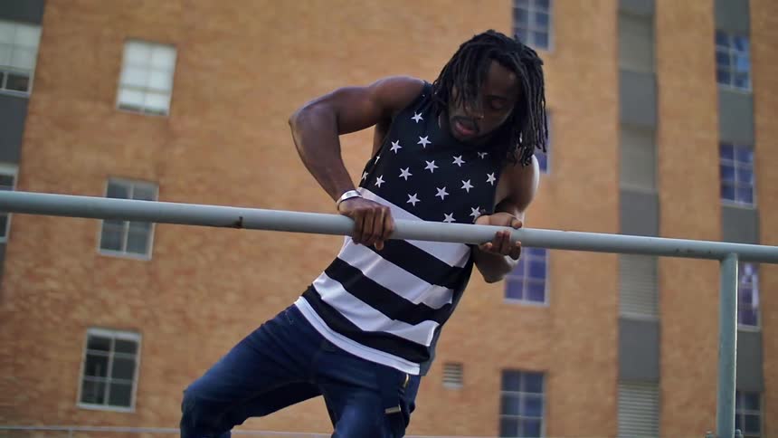 Man jumping over a metal bar in the city
