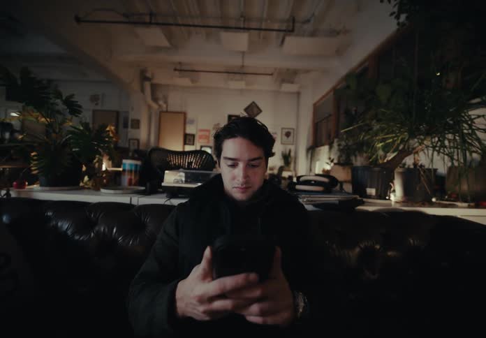 Man picking up a smartphone and starting to type