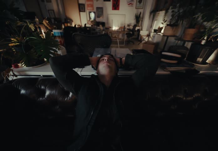 Man putting his hands on his head and leaning on the couch