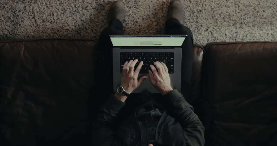Pair of hands of a person typing on a laptop