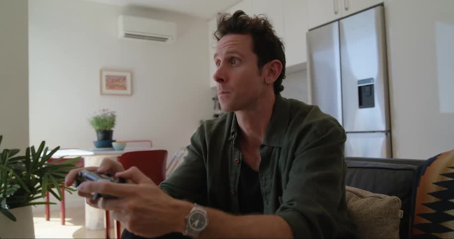 Man sitting on a couch holding a video game controller