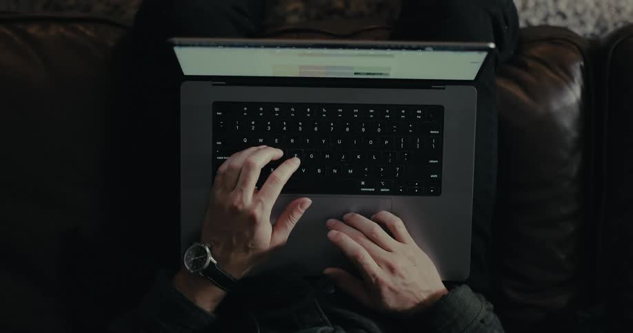 Man scrolls on his laptop screen using its touch pad