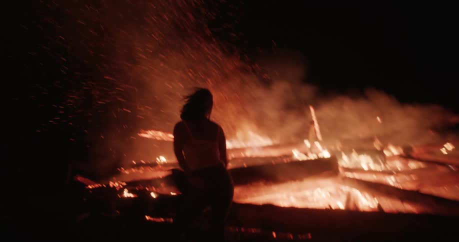 A clip of a lady dancing by the burn fire