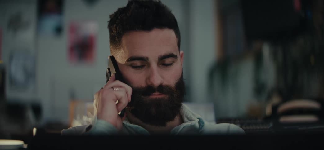 Portrait of a bearded man talking on a cell phone