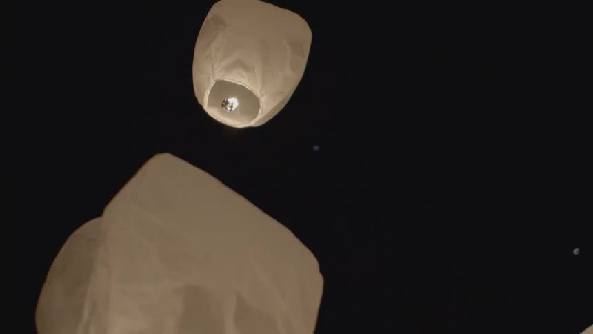 Illuminating lanterns float into the night sky