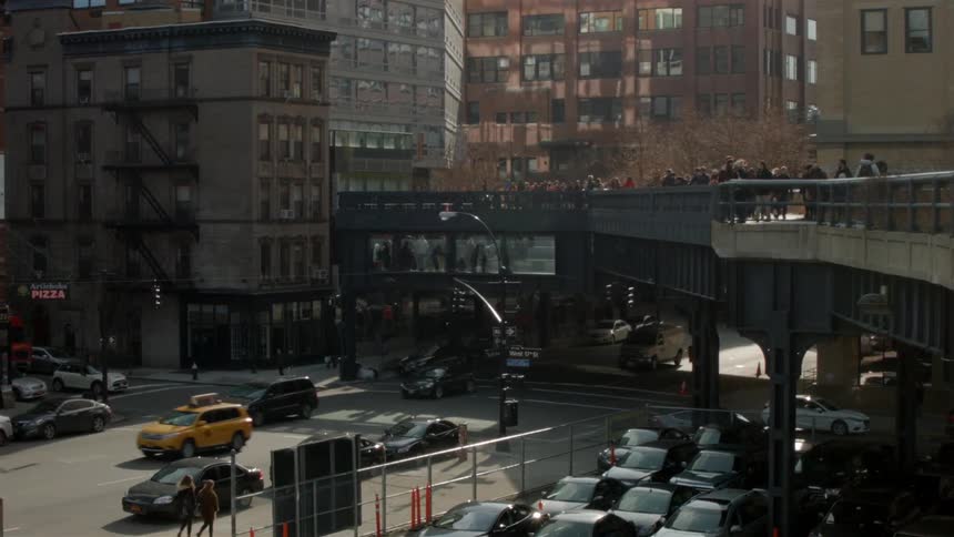 Cars traveling under a walkway bridge in busy city