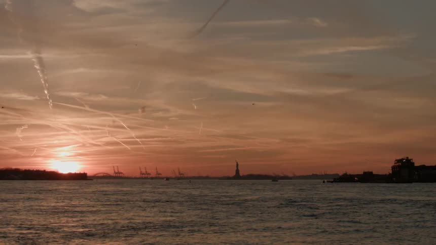 The sun is setting over the rough waters
