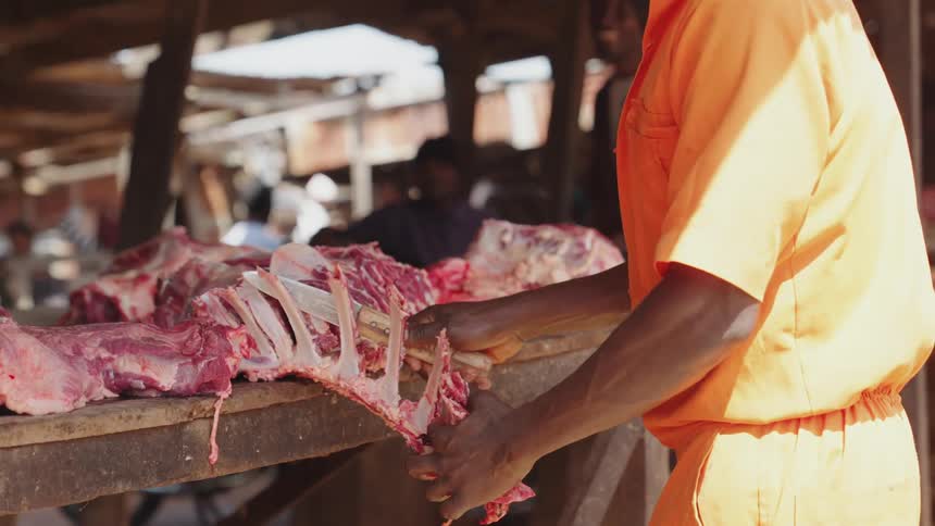 Hand with a knife shredding meat from the bone