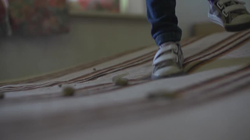 A child bouncing on a bed covered with rocks