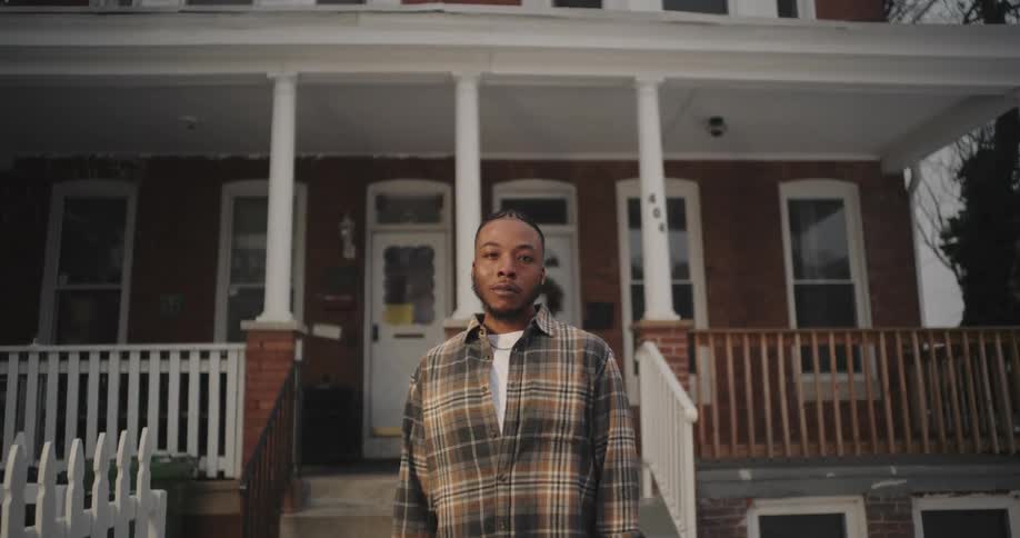 A man is standing by his porch
