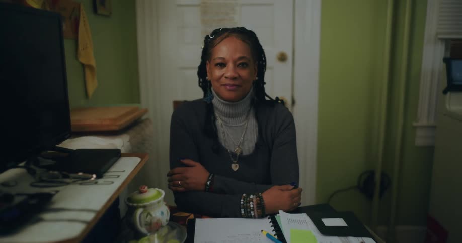 Woman with arms crossed sitting at an office desk